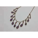 A gilt metal mounted amethyst necklace hung with graduated pear shaped stones