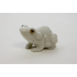 A carved white stone model of a frog with glass eyes, 7cm wide