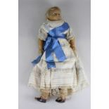 A late 19th century wax head and shoulder doll with short blond hair and fixed blue eyes, wax legs