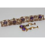 An amethyst bracelet rubover set with ten oval cut stones in scrollwork mounts and a pair of