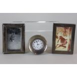 A George V silver mounted circular travel clock, 7cm, and two small silver photograph frames