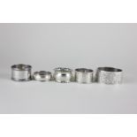 Four Edwardian and later silver napkin rings, various dates and makers, together with a floral and