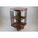 A mahogany revolving book stand with slatted sides, on castors, 54cm