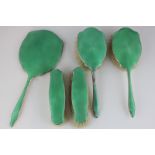 A George V silver and green enamel backed dressing table set comprising hand mirror, two hair