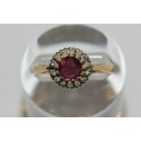 A ruby and diamond ring the circular cut stone multi claw set within a border of small eight cut