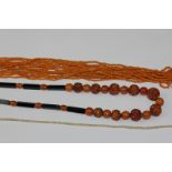 An amber coloured bead and black onyx necklace and another string bead necklace; (NC)