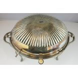 A silver plated revolving oval breakfast dish with strainer and locking pin on four reeded curved