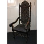 A carved oak high back chair with scroll arms and solid seat, on turned supports and stretchers (