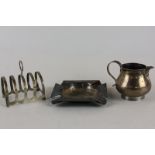 A small silver cream jug, London 1918, a small silver toast rack and a silver ashtray, 8oz