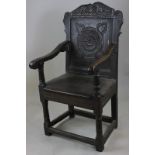 A 17th century oak wainscot chair with carved panelled back and turned legs joined by stretcher