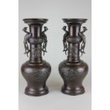 A pair of Japanese bronze vases decorated with dragons and chrysanthemums with phoenix shaped