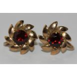 A pair of garnet earrings, claw set in a flower head design in 9ct