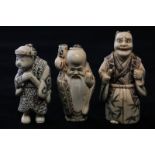 Three early 20th century Japanese carved ivory and decorated netsukes of a devil, a sage and a man