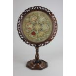 An early 19th century mahogany table top circular screen on column with fretted frame and floral