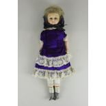 A late 19th century wax head and shoulder doll with blue fixed eyes, blond hair, in Victorian