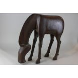 A carved wooden figure of a grazing horse (lacks tail), 47cm high, (NC)