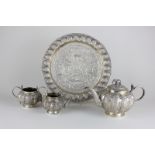 An Indian silver three piece tea set on matching tray, melon fluted, profusely chased with leafy