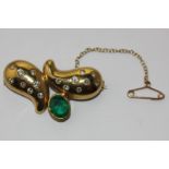 An emerald and diamond brooch rubover set with an oval cut emerald and gypsy set with graduated