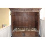 A 17th century and later enclosed oak bedstead, with panelled sides and applied carved decorated