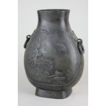 A Japanese bronze vase with two ring handles, cast with a scene of buildings, trees and crescent