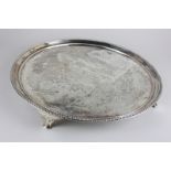 A George IV silver salver, circular shape with beaded border, floral decoration and presentation,