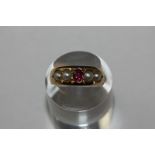 A ruby and pearl ring with a central circular cut ruby