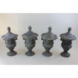 A set of four lead garden urn ornaments with covers and pineapple finials  59cm high (NC)