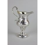 A George III silver cream jug, baluster shape, beaded handle and rim, later repoussé decorated