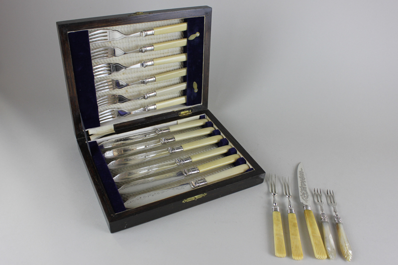 A silver plated cased fish knife and fork set with white handles, together with a pair of