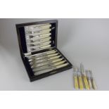 A silver plated cased fish knife and fork set with white handles, together with a pair of