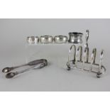 A George V silver toast rack, Birmingham 1933, together with a pair of Victorian sugar tongs and