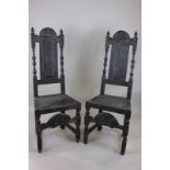 A pair of 17th century carved oak high back chairs, the back panels carved with figures, with turned