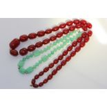 An cherry amber bead necklace graduated ovoid beads, 131.5g; and a glass bead necklace