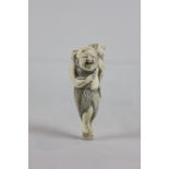 A 19th century carved ivory netsuke of a laughing fisherman with fish, 6cm tall, (NC)