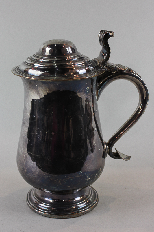 An 18th century Sheffield plate tankard with hinged lid, baluster body and scroll handle