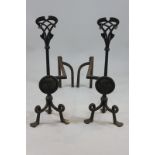 A pair of Arts and Crafts style cast iron fire irons with heart shaped terminals, 68cm high, (NC)