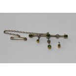 A demantoid garnet and diamond bar brooch loose hung with three knife edge bars