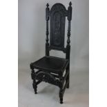 A 17th century carved oak high back chair with back panel carved with a crowned figure, turned