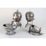 Two silver plated spoon warmers, one in the form of a shell on rocky base, together with two egg