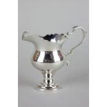 An Edward VII Britannia standard silver cream jug with serrated rim and scroll handle, maker Harry