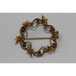 A ruby circlet brooch leaves and scroll set with six small round stones (NC)