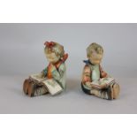 Two Goebel Hummel figures of a boy and girl reading, modelled as bookends, together with a Hummel