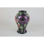 A Moorcroft anemone pattern vase with green and blue ground, stamped and dated 2003 to base, 24cm