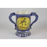 A faience two handled mug depicting farm scenes, 18.5cm high