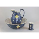 A Devonware Pottery ewer and bowl and brush holder, in the daisy pattern on blue ground