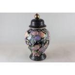 A Chinese porcelain ginger jar and cover, black ground decorated with fruit and foliage in pastel