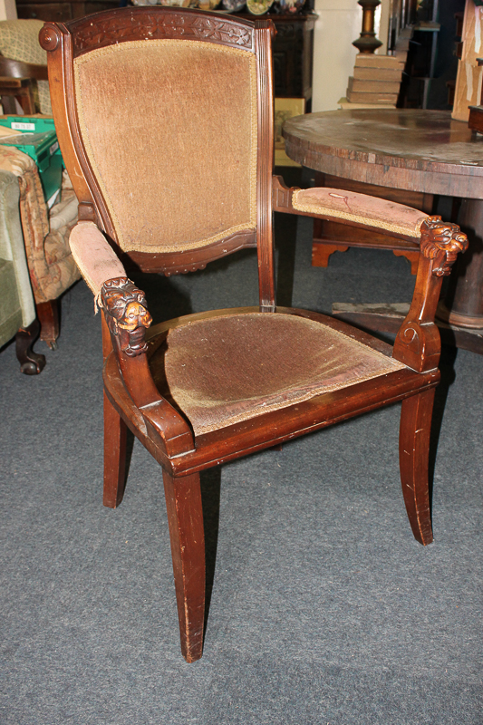 A mahogany framed elbow chair with upholstered back, seat and arms, open sides, lion's head arms and