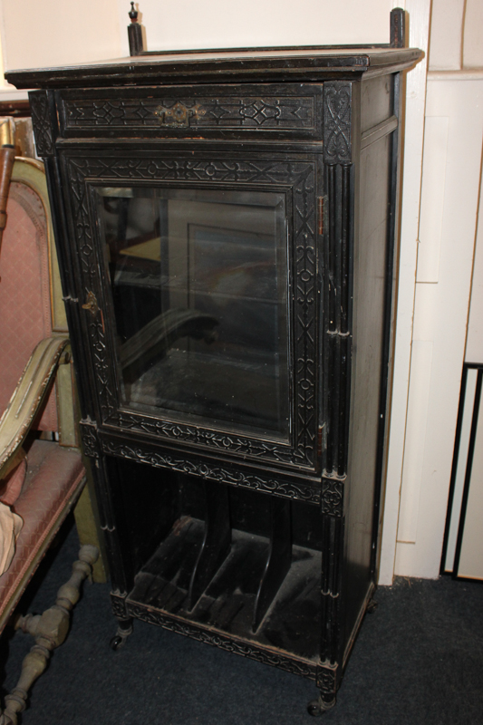 A Victorian ebonised music cabinet with single drawer above glazed door, on canterbury base,