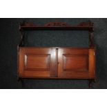 A mahogany wall unit, one shelf above two panel doors enclosing a cupboard with one shelf 62cm