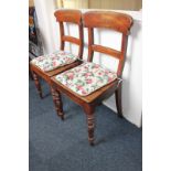 A pair of mahogany dining chairs with curved back and solid seat, on turned legs